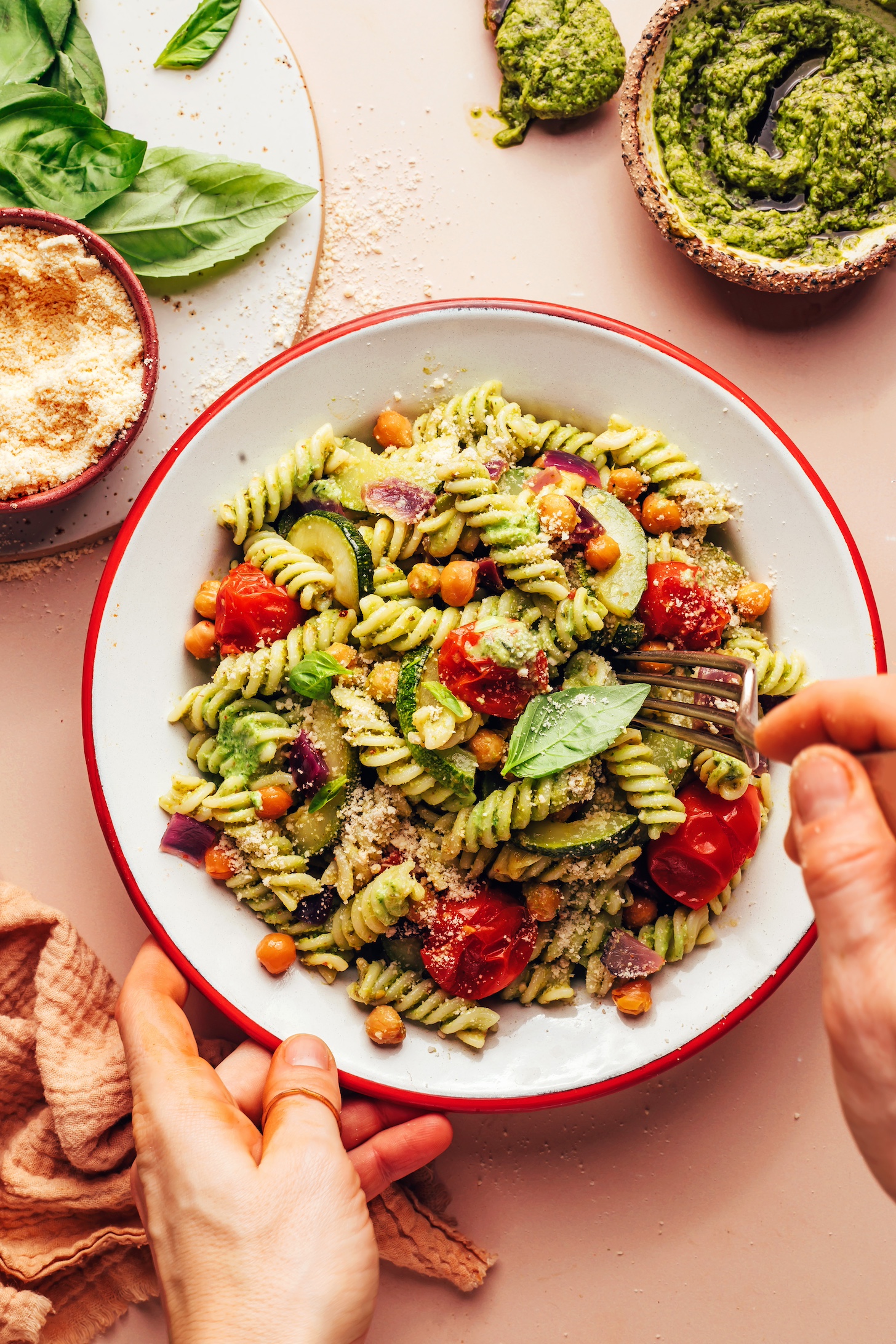 Using a fork to pick up a bite of Zucchini Pesto Pasta with Roasted Tomatoes & Chickpeas