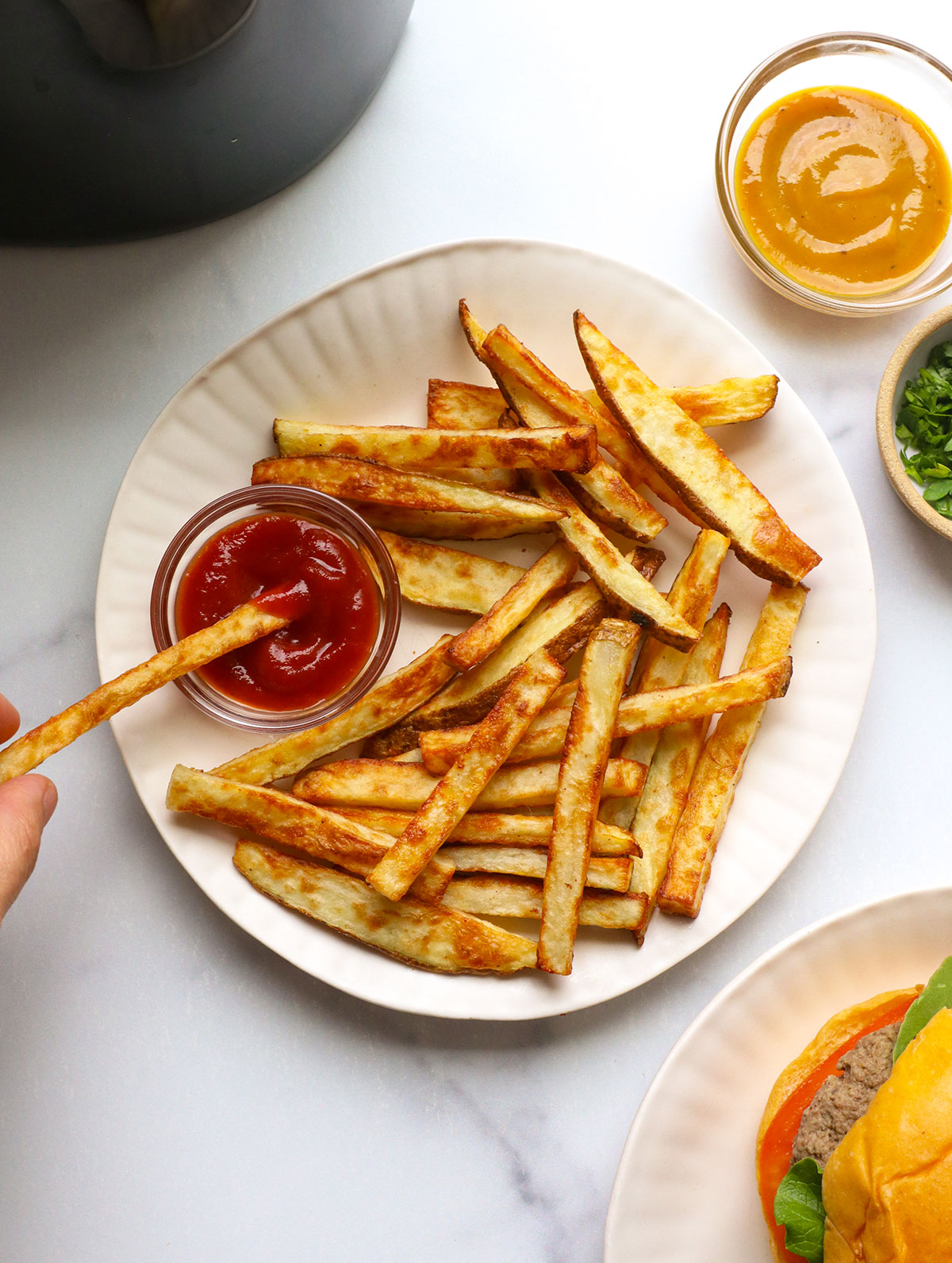 french fry dipped into ketchup on a white plate.