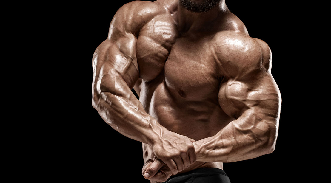 Muscular bodybuilder flexing his arm muscles after following the 5x5 workout method