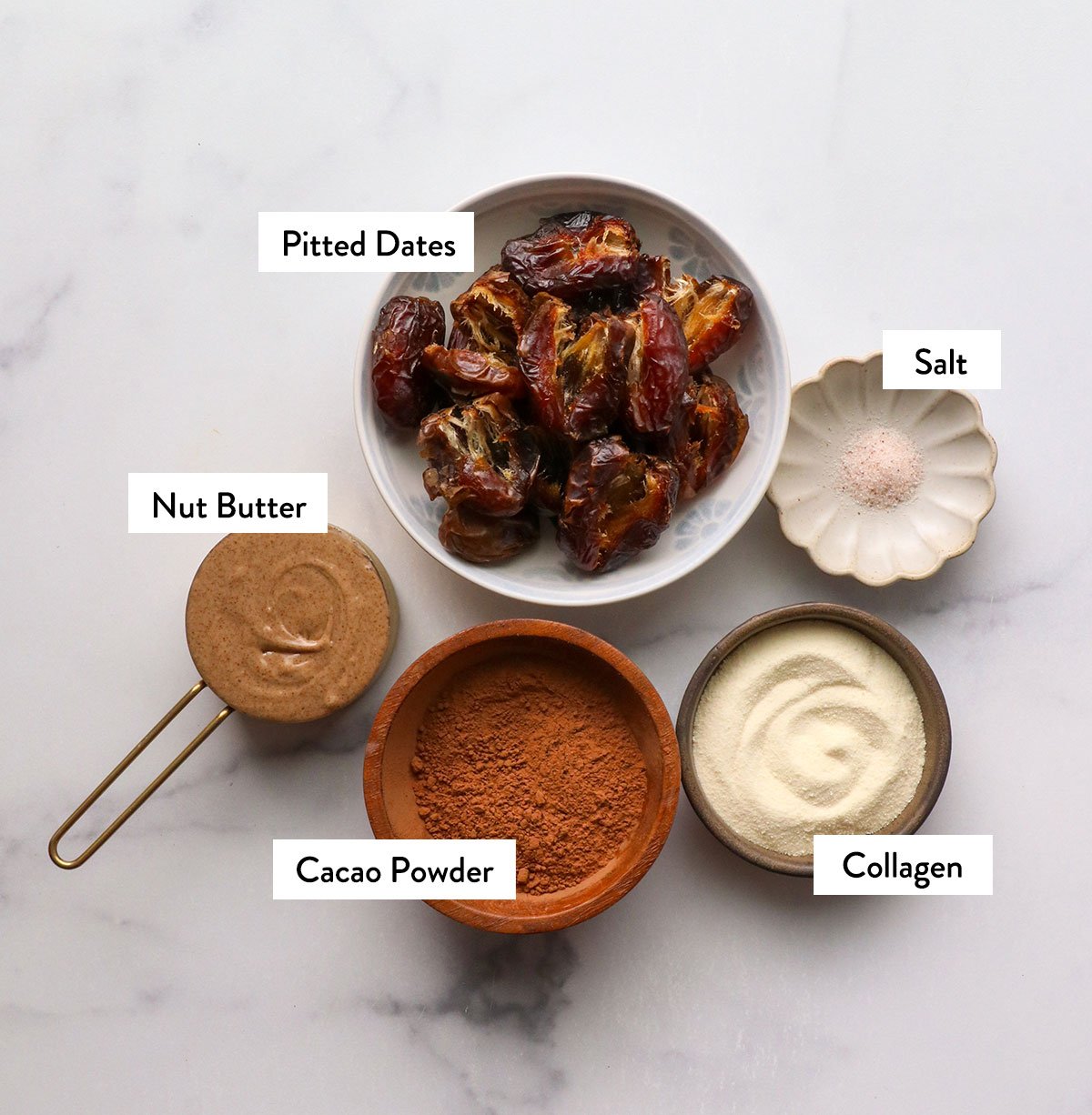 dates, nut butter, cocoa powder, collagen and salt labeled in bowls.