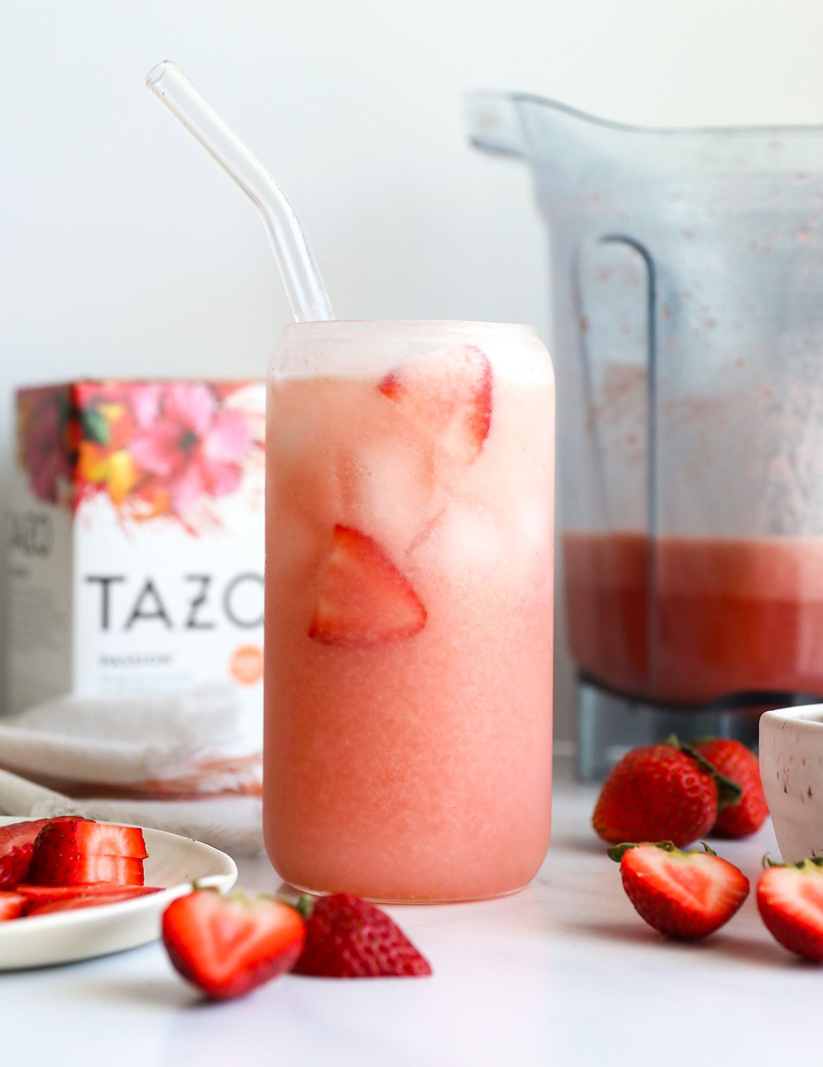 homemade pink drink in a glass with fresh strawberries.