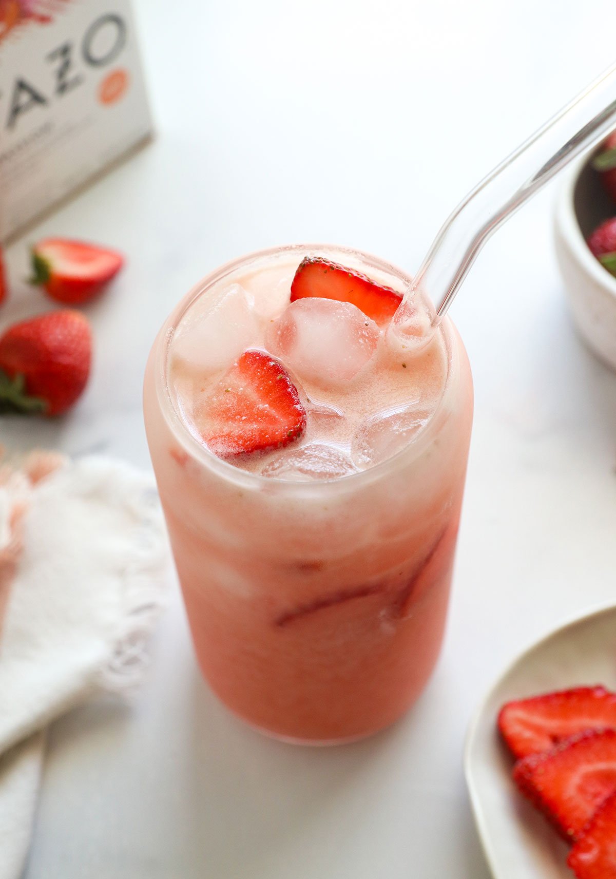 DIY pink drink in a glass with fresh strawberries.