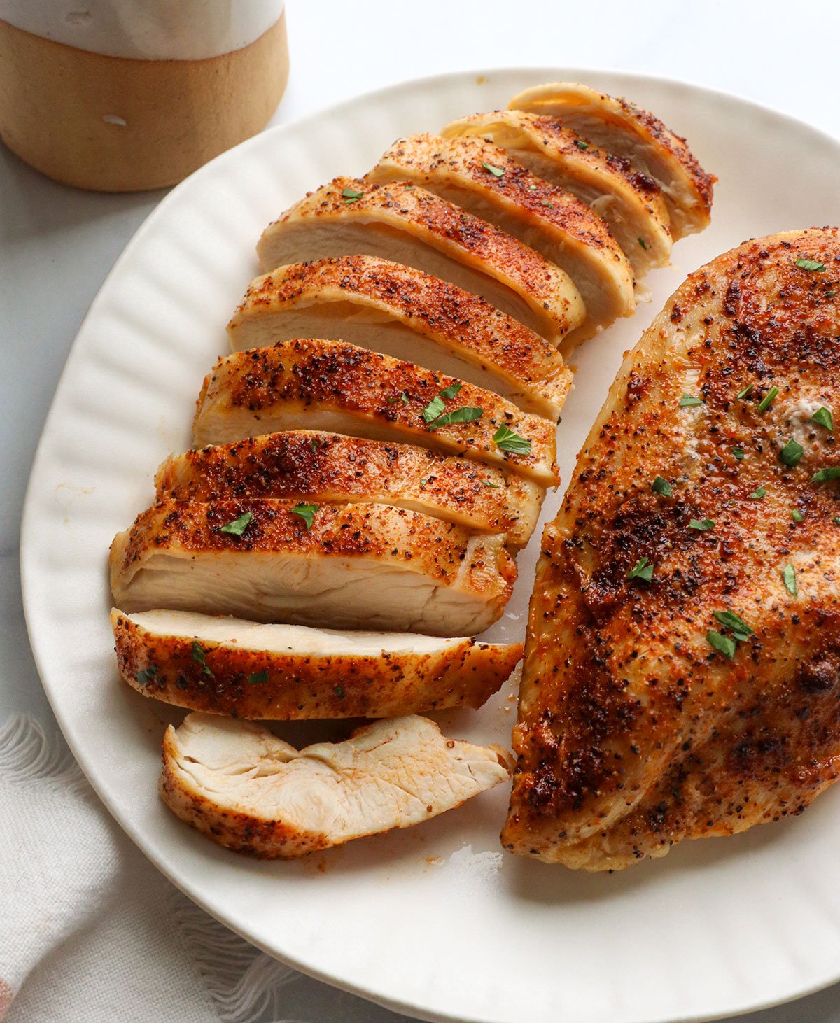 air fryer chicken sliced on a plate.