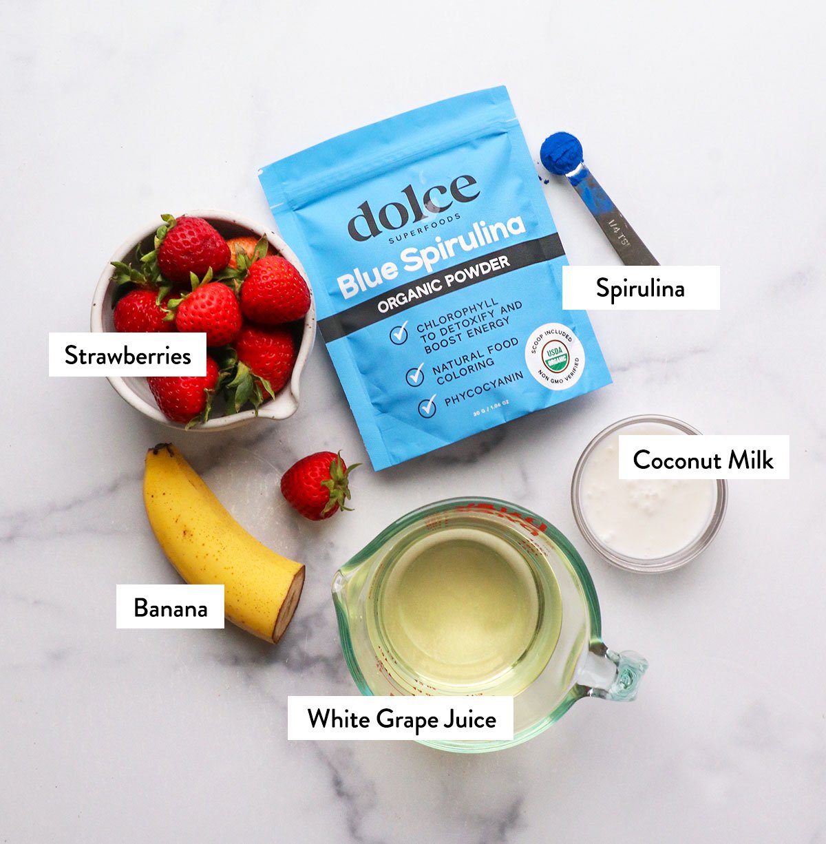 strawberries, banana, and juice labeled on a white surface. 