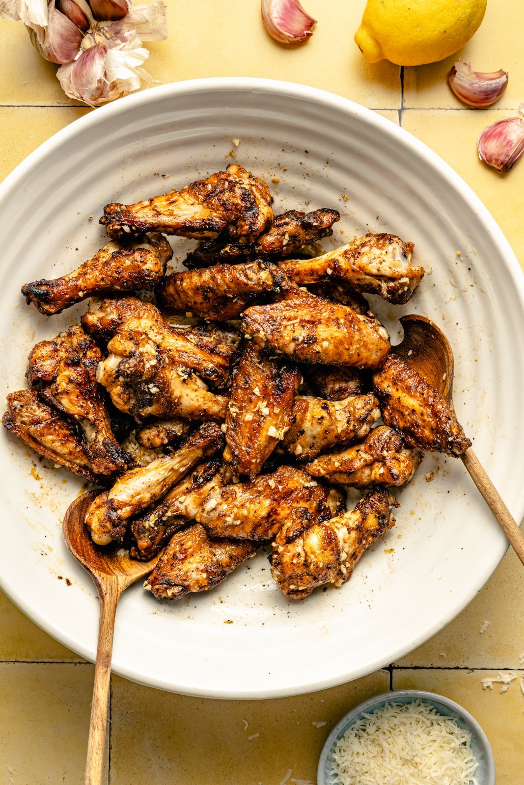 tossing lemon garlic parmesan chicken wings in a bowl