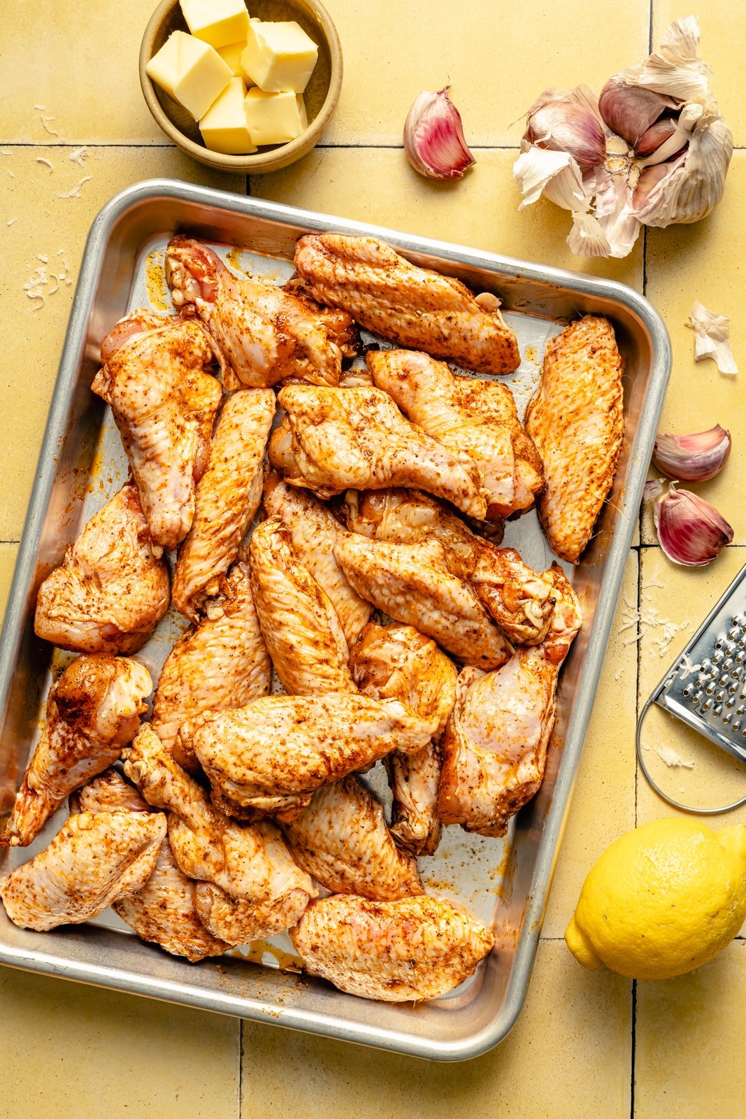 seasoned chicken wings uncooked on a baking sheet