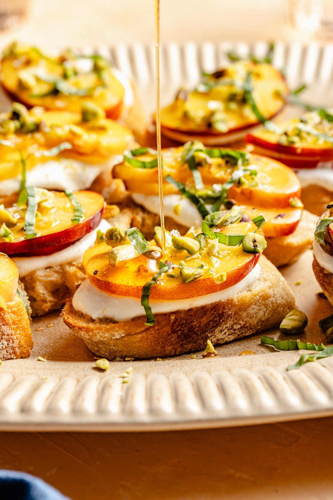 drizzling honey on peach crostini