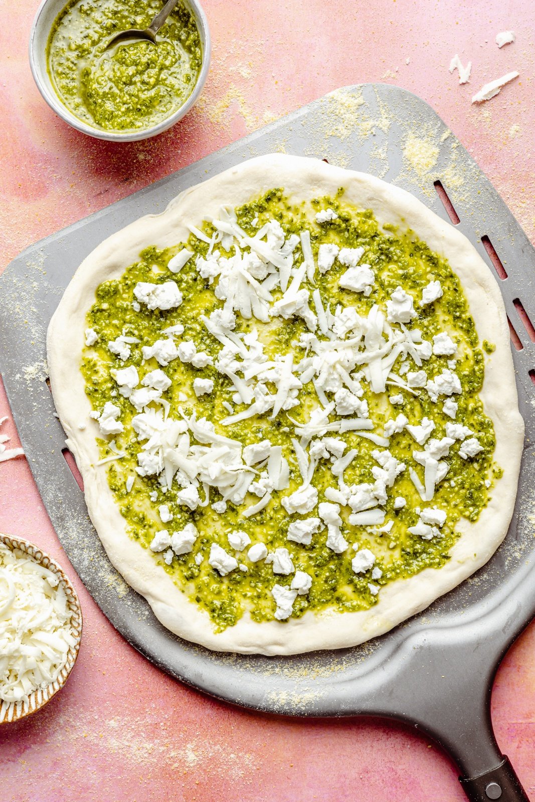 unbaked pesto peach pizza on a pizza peel