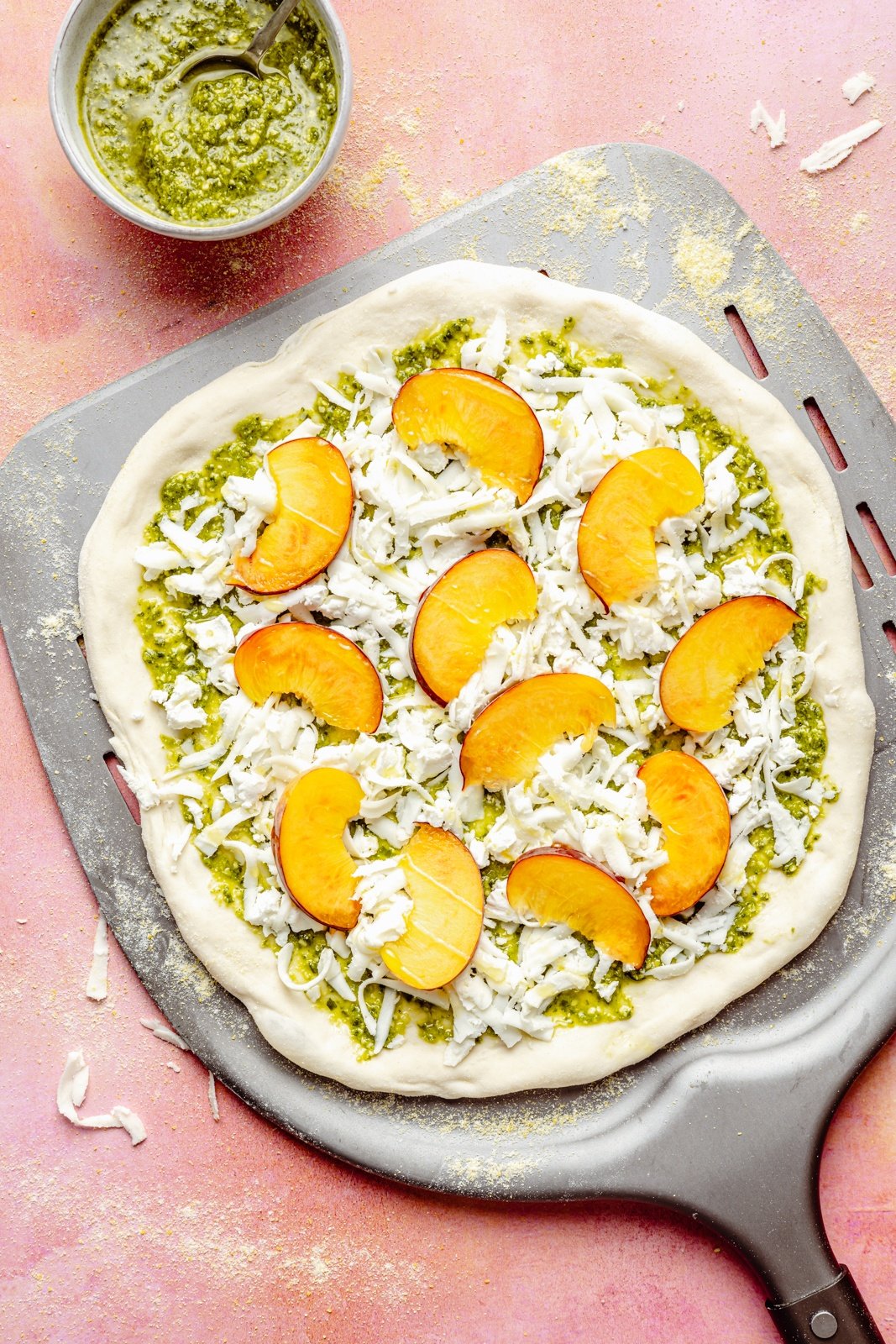 unbaked peach pizza on a pizza peel
