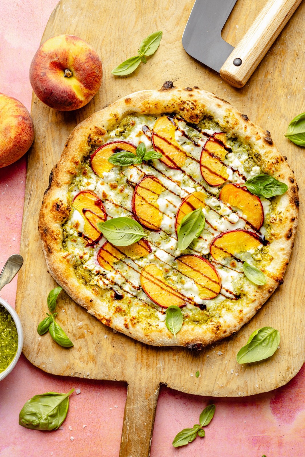 pesto peach pizza on a wooden serving board