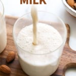 almond milk poured into a cup and labeled for pinterest.