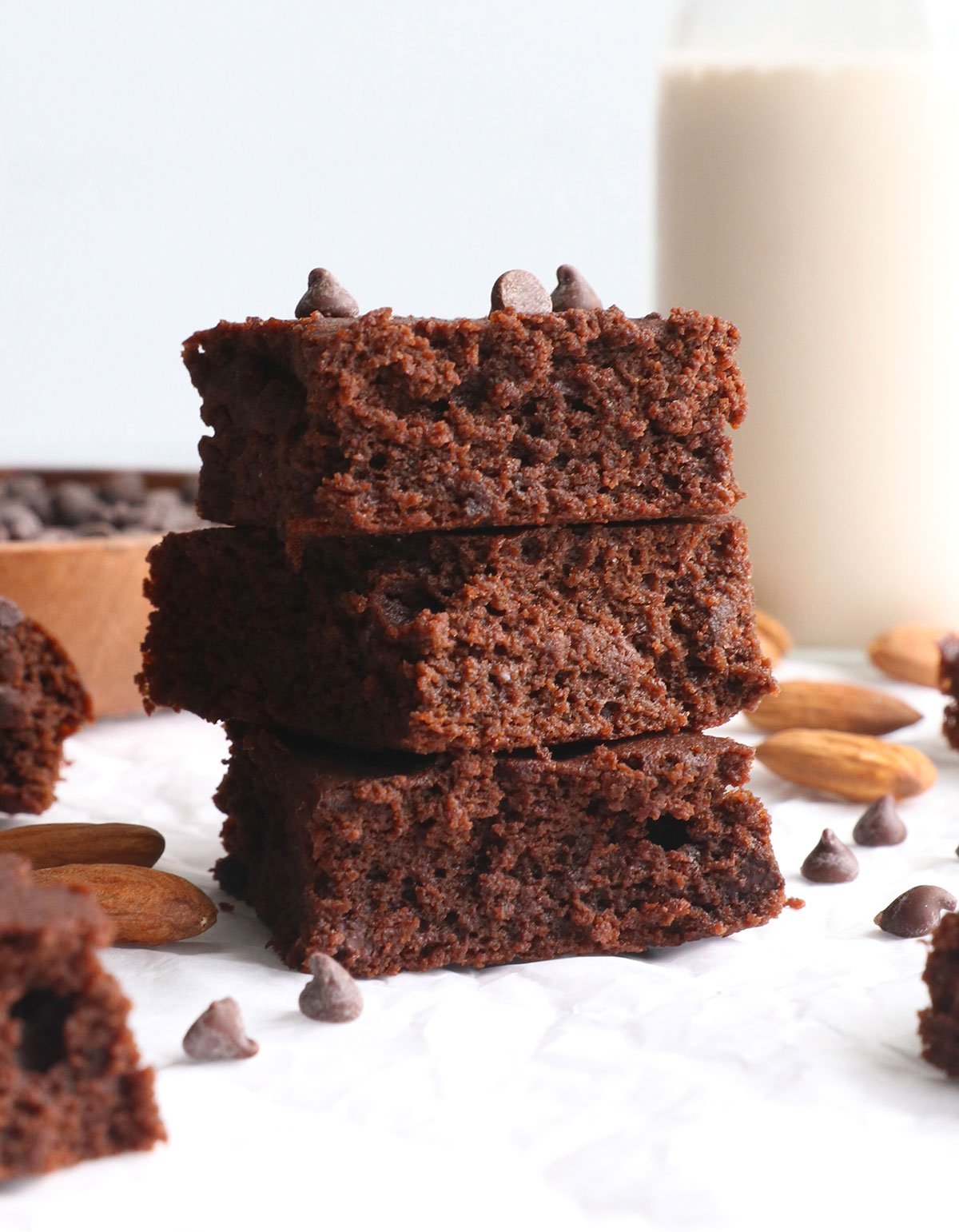 almond pulp brownies stacked on white parchment.