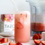 homemade pink drink in a glass with fresh strawberries.