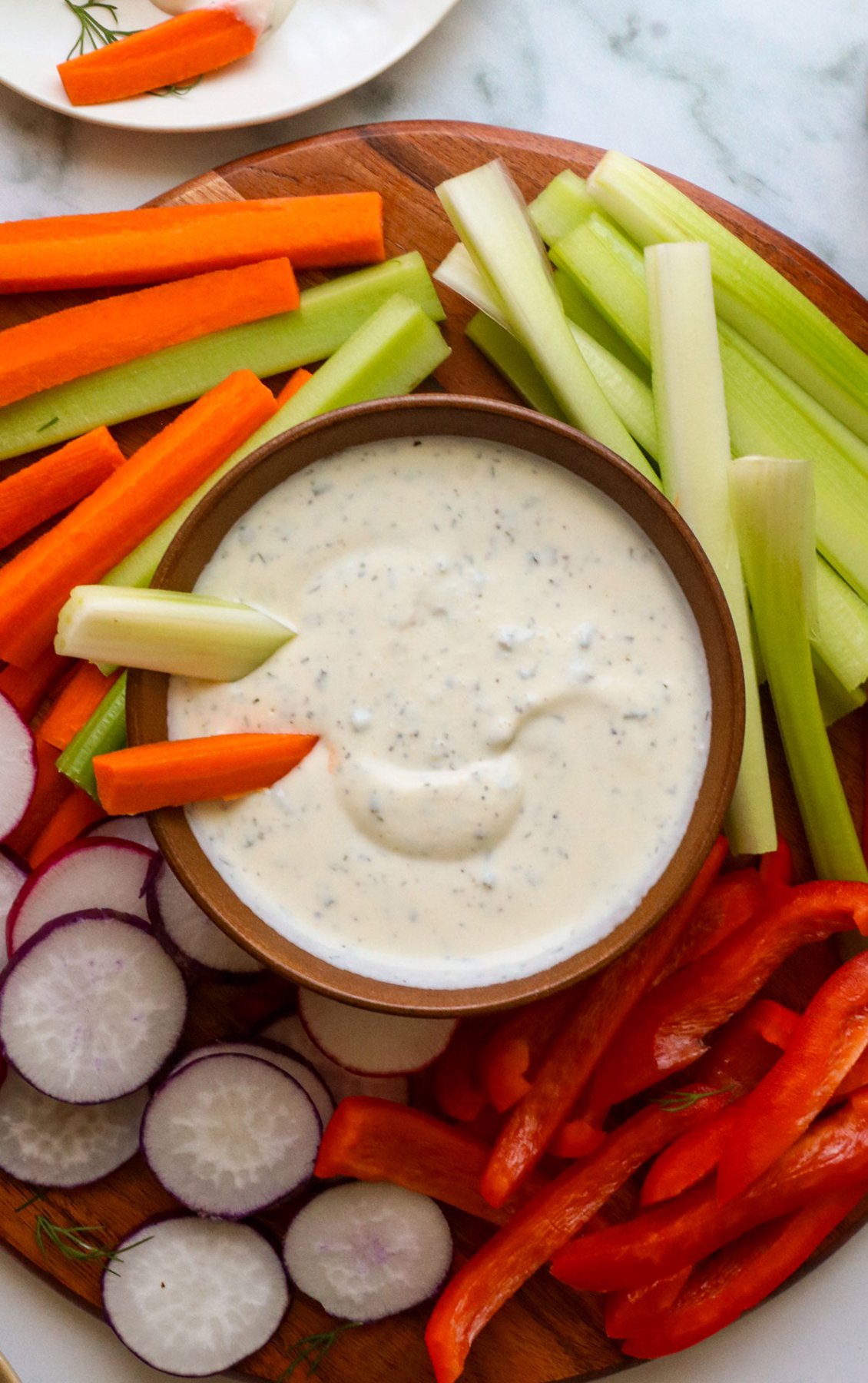 greek yogurt ranch dressing in a bowl served with sliced veggies.