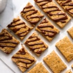 homemade protein granola bars cut into small pieces and some topped with chocolate.