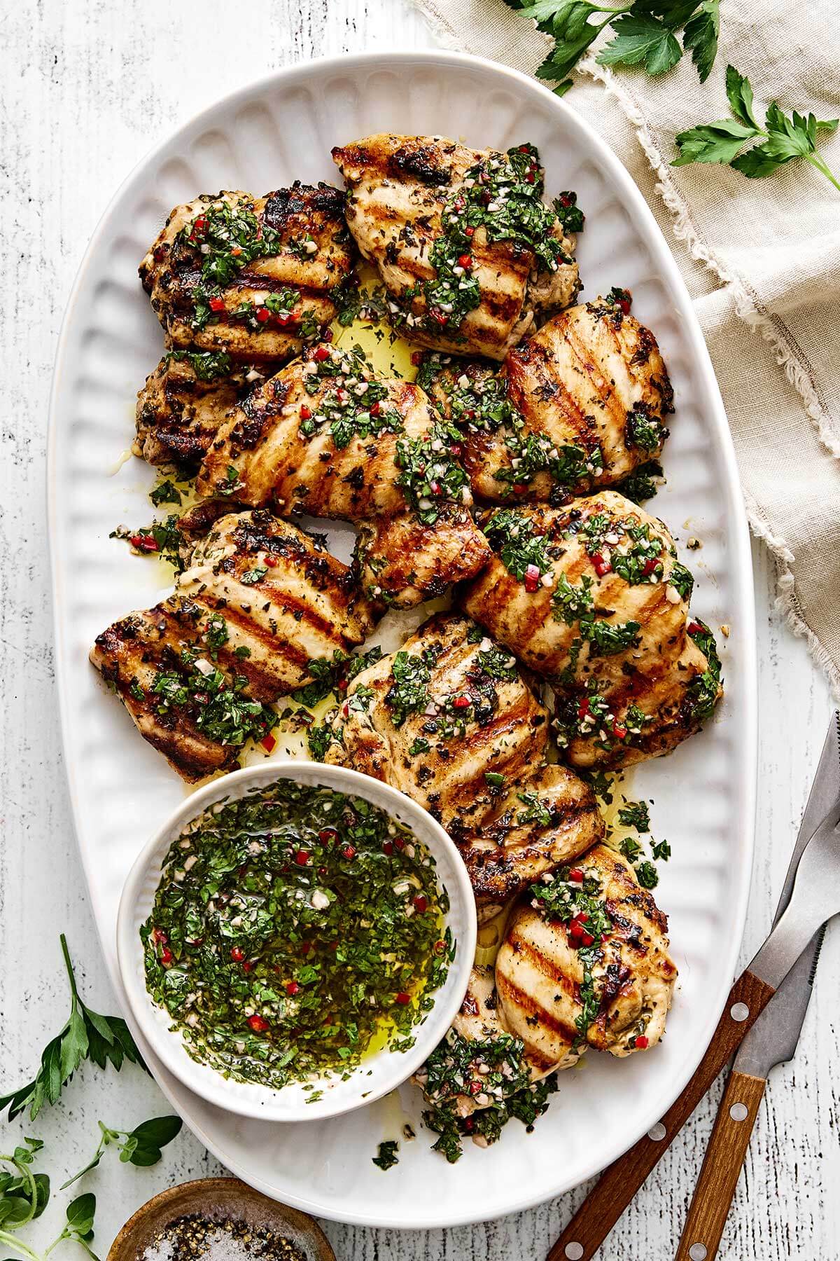 A plater of grilled chimichurri chicken thighs.