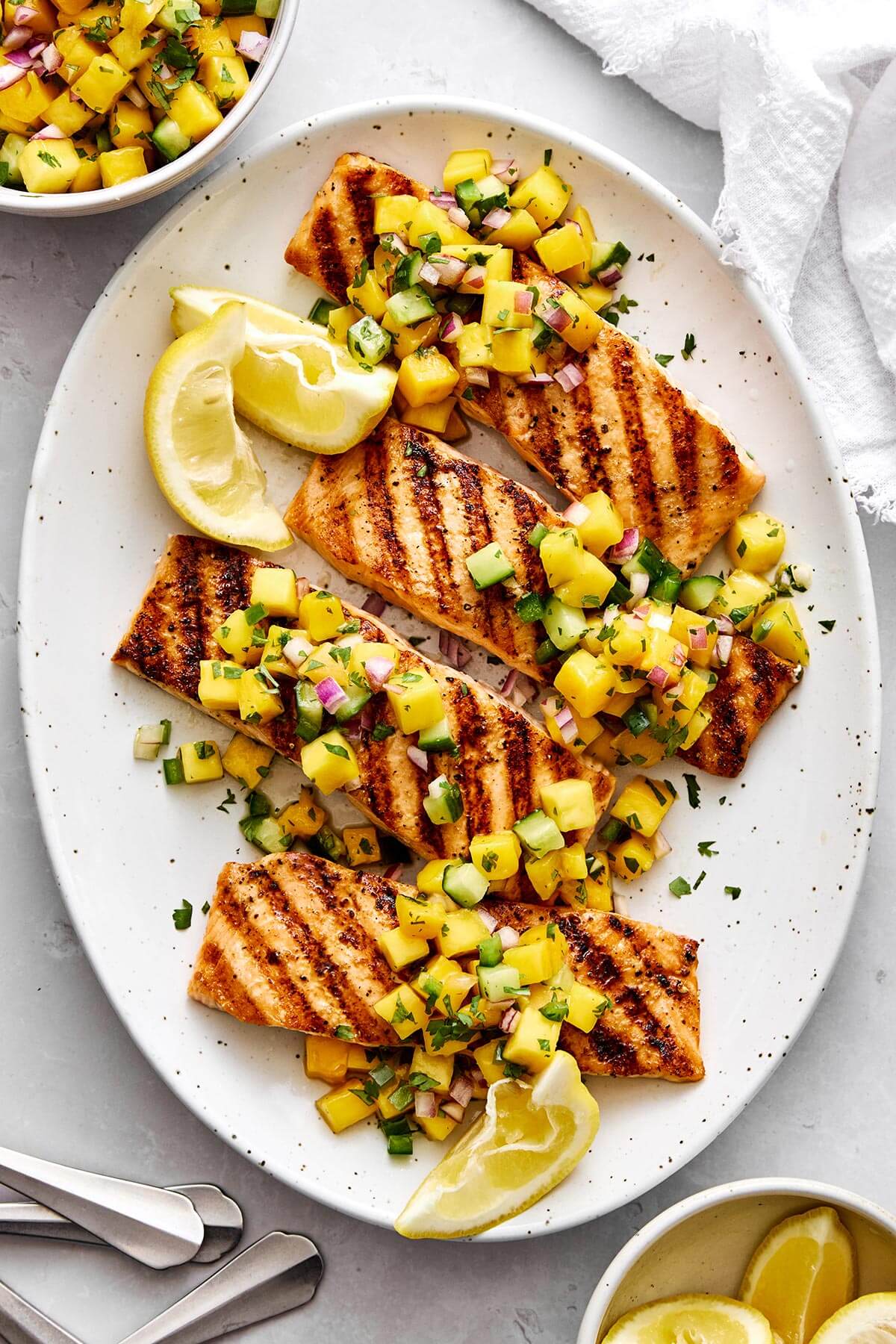 A platter of grilled salmon with mango salsa.