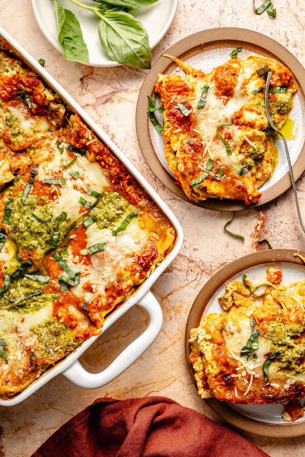 vegetarian lasagna in a pan with slices on two plates