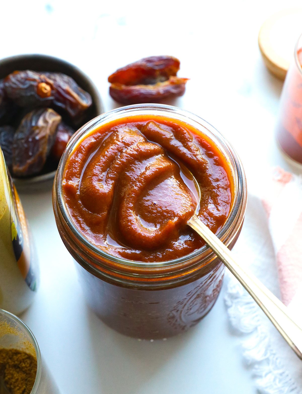 BBQ sauce at an angle in a jar with a spoon.