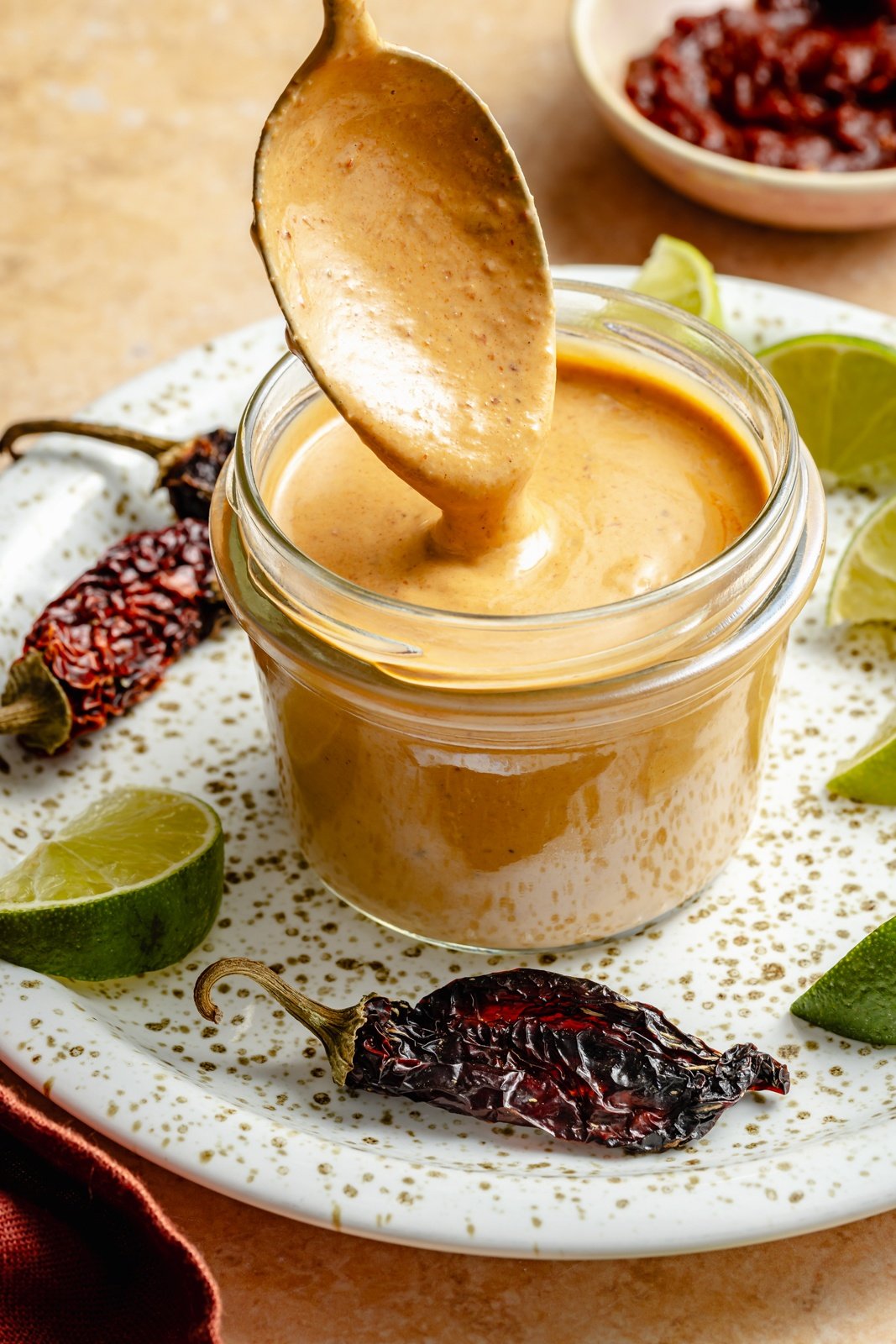 spooning chipotle sauce out of a jar
