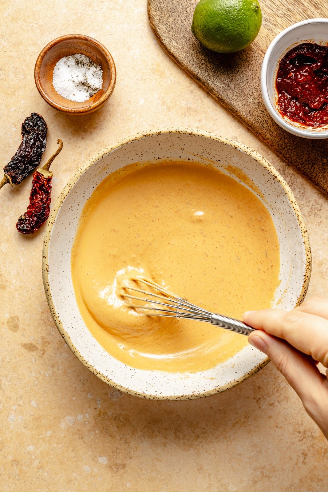 whisking chipotle tahini sauce in a bowl