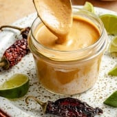spooning chipotle tahini sauce out of a jar