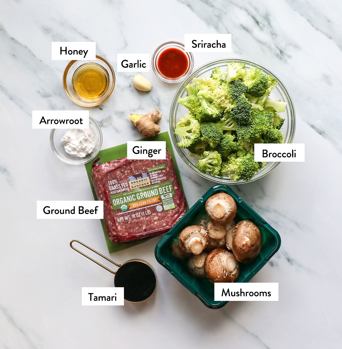 beef, mushrooms, broccoli, sriracha, honey, arrowroot, ginger, and garlic labeled in bowls.