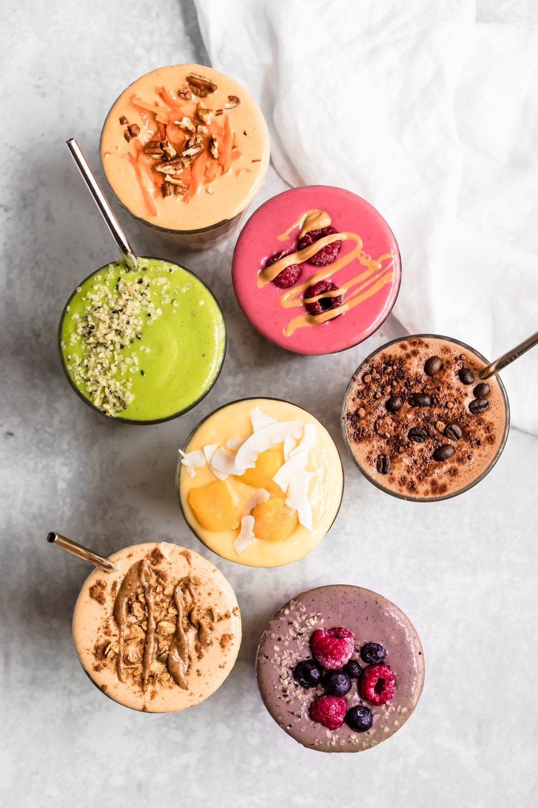 top-down view of 7 smoothies in glasses