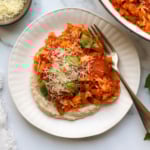pizza stir fry on white bean dip on a plate.