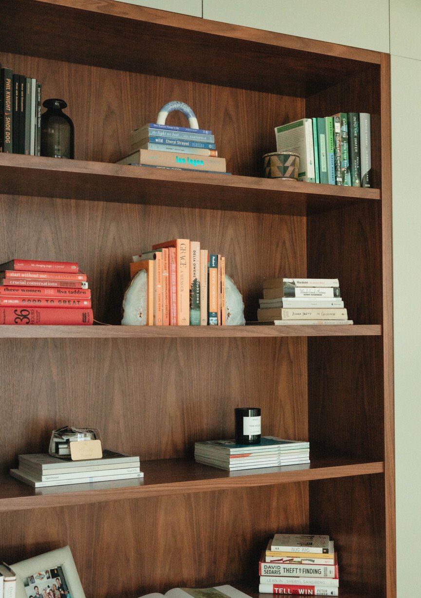 brown bookshelves with stacked books and sculptural decor