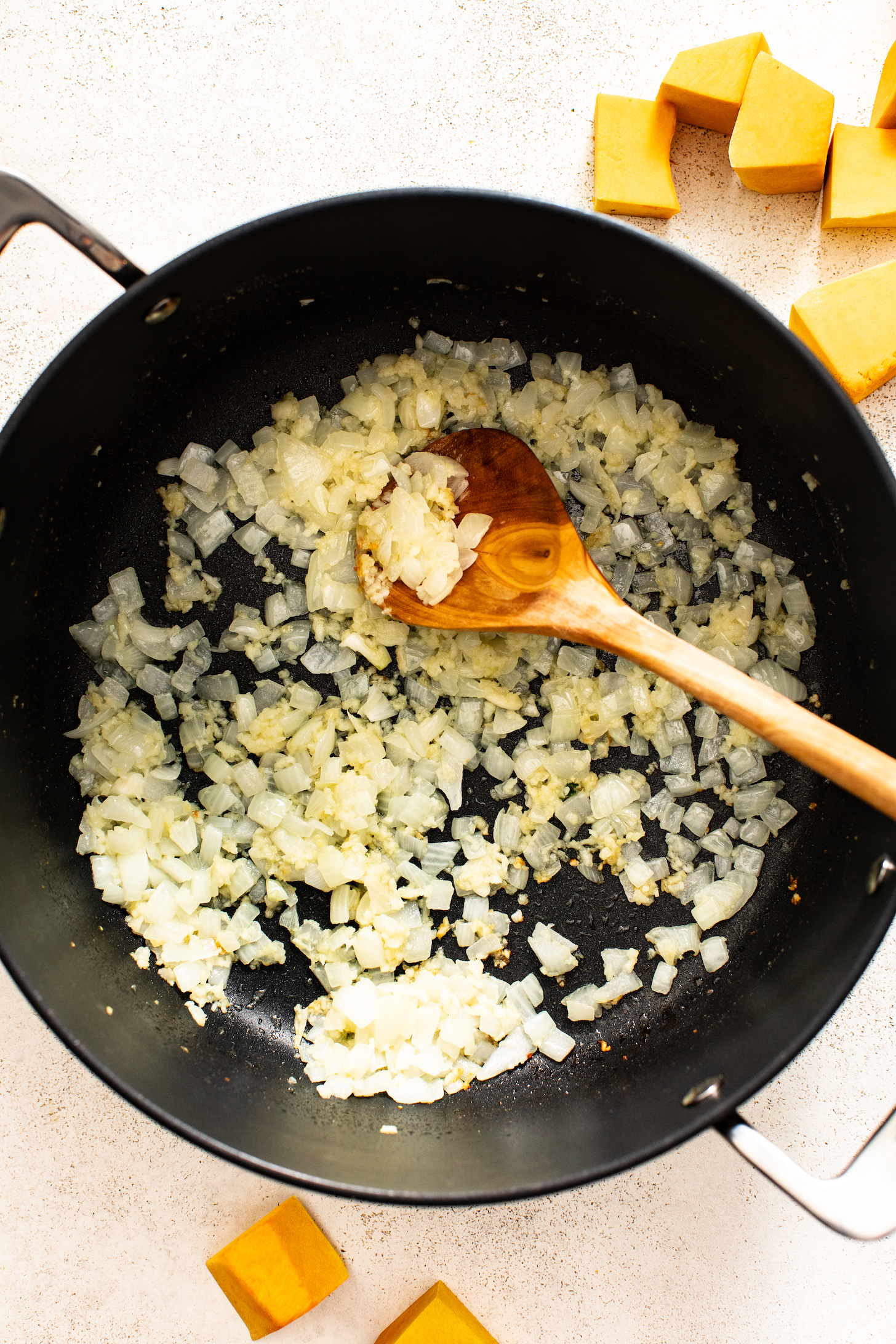 Wooden spoon in a pot of sautéed diced onions