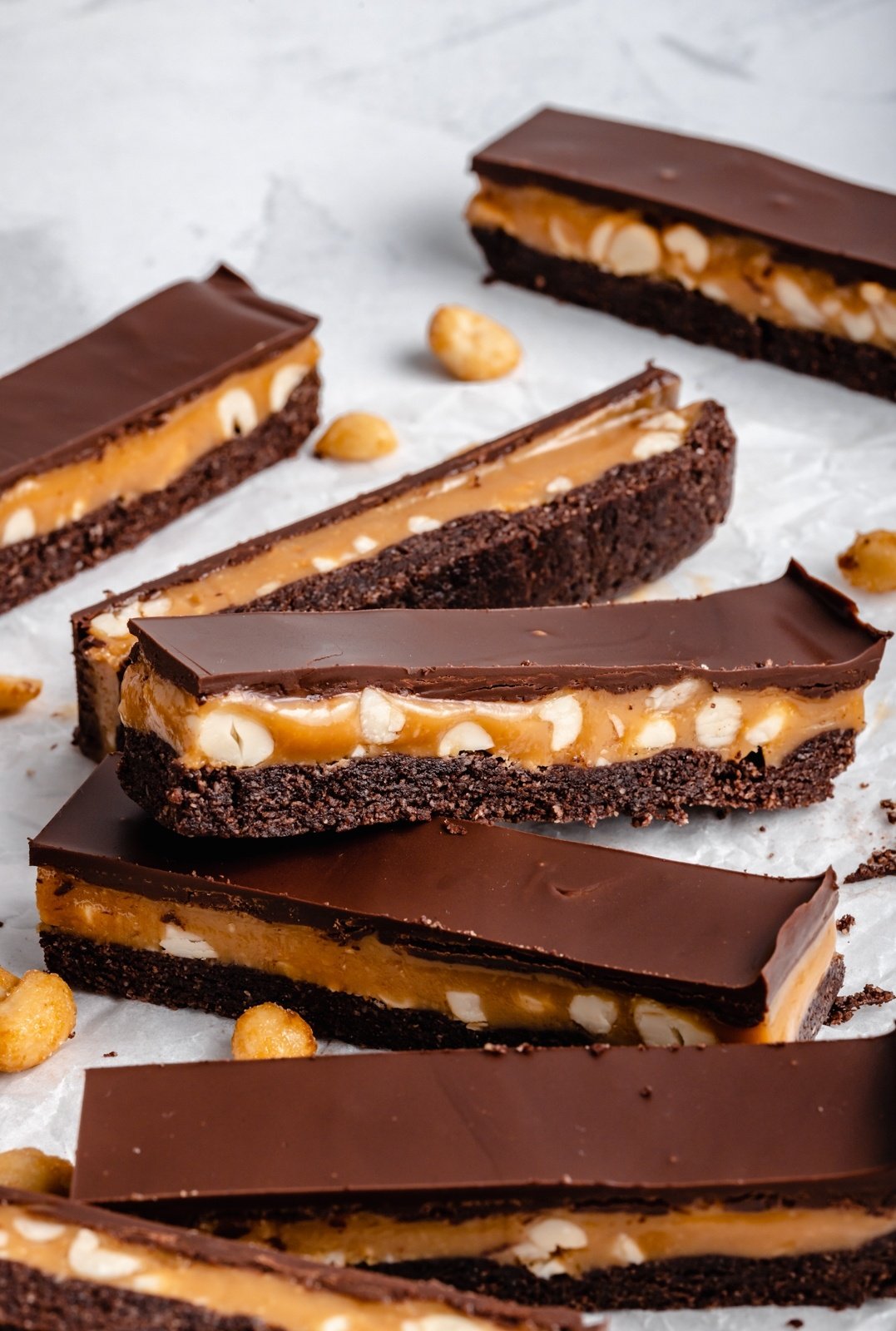 vegan chocolate peanut butter caramel bars on parchment paper