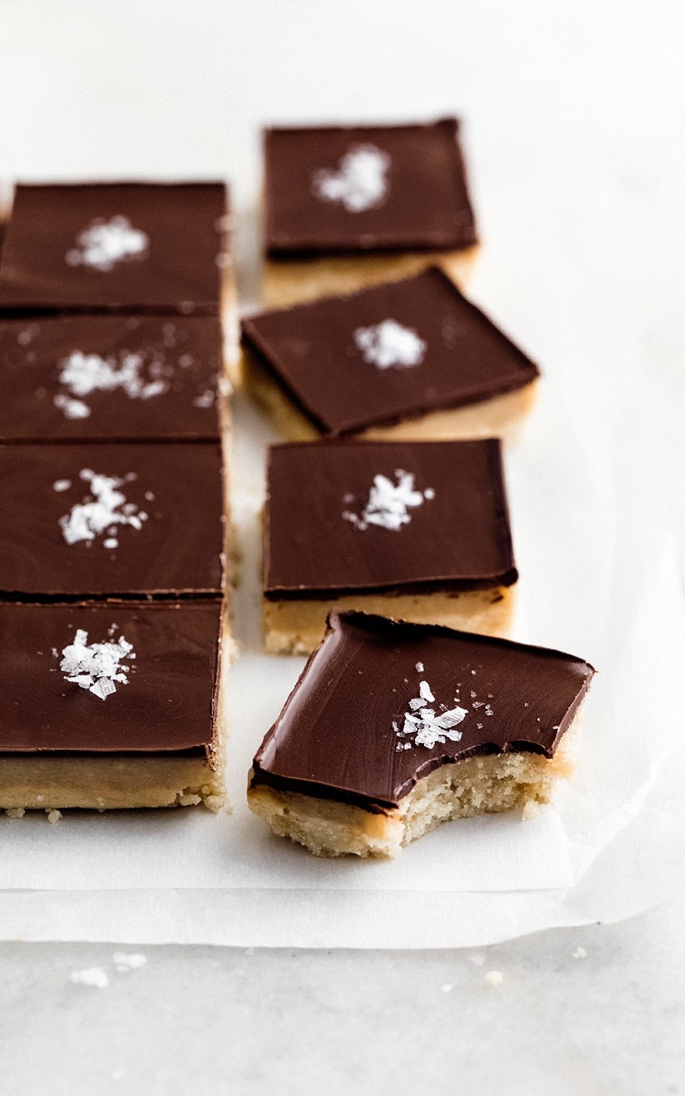 caramel millionaire bars on parchment paper