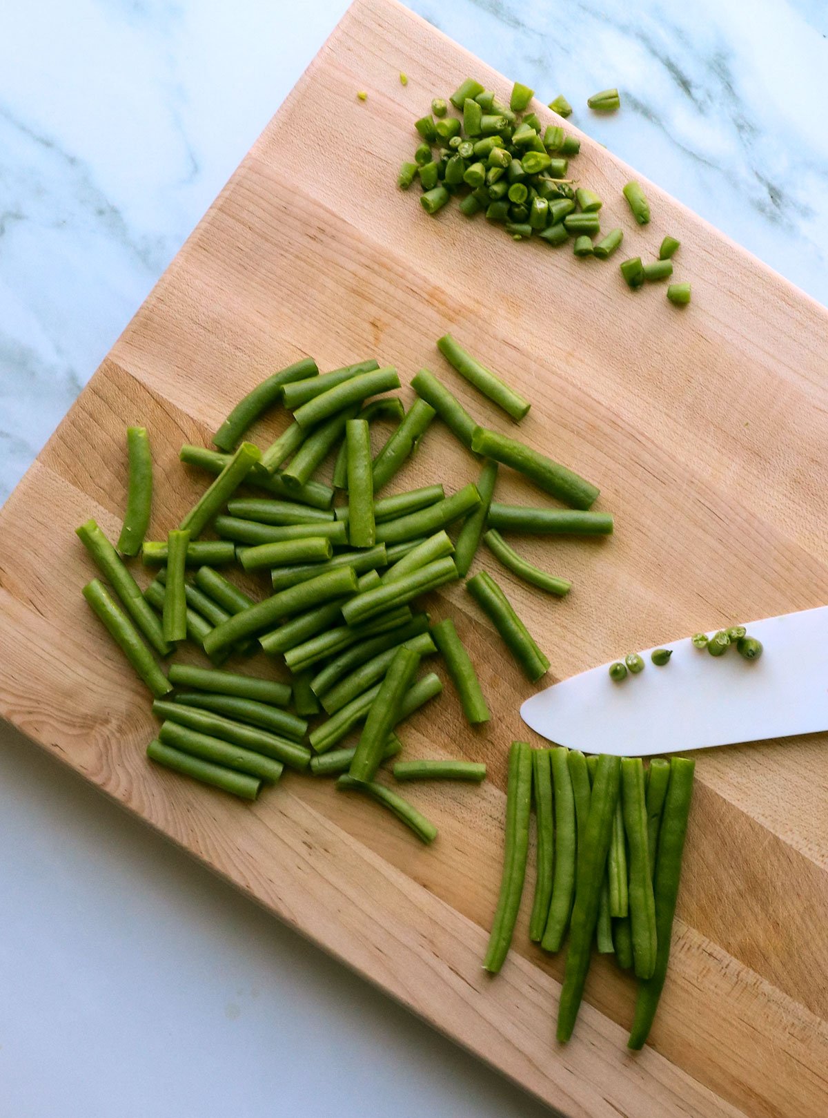 green beans cut into small pieces on a cutting board.