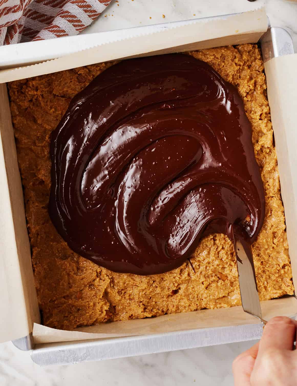 Spreading melted chocolate over bars with offset spatula