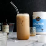 iced protein latte with a glass straw on a black background.