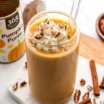 pumpkin smoothie topped with whipped cream in a glass.