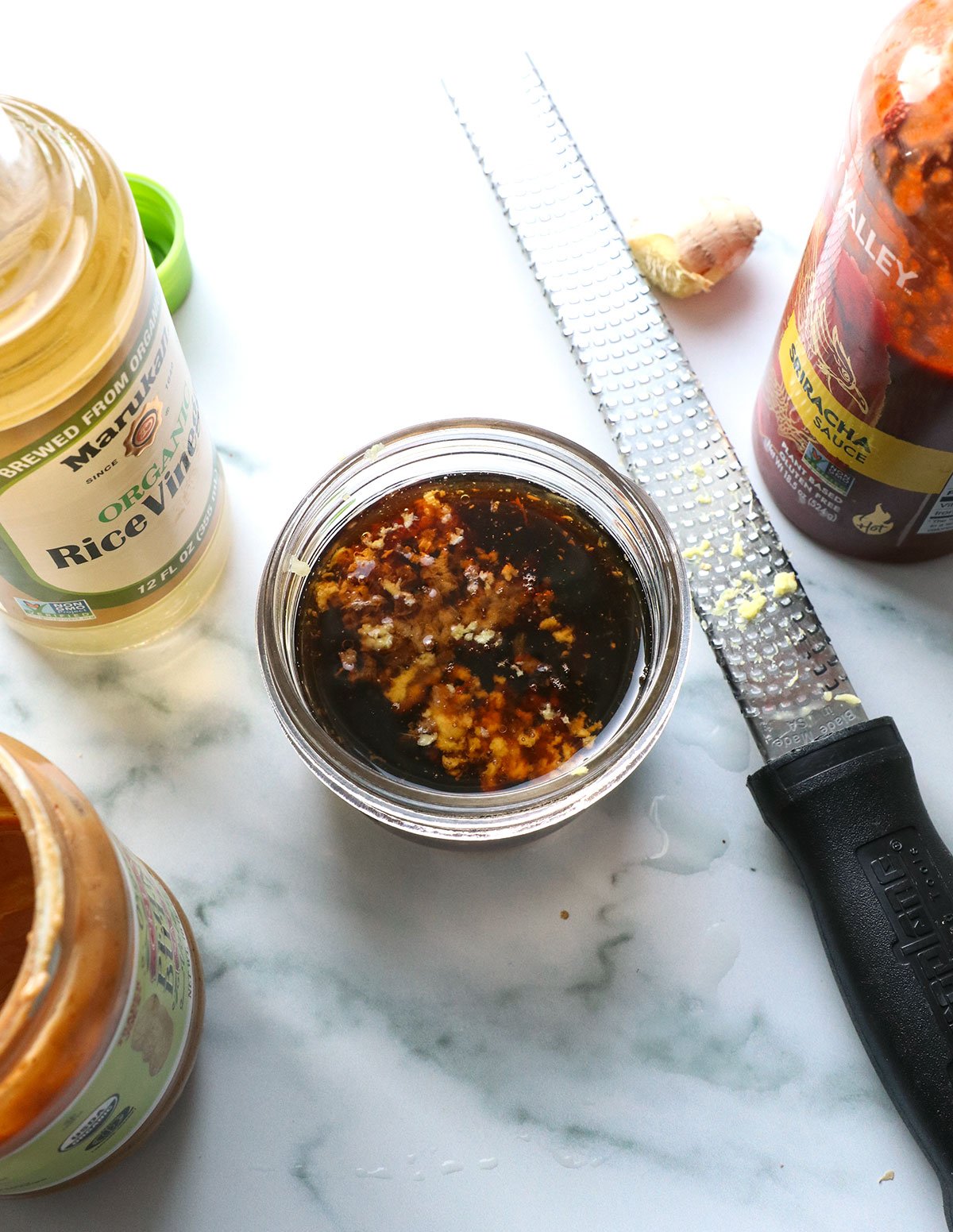 ginger and garlic grated into a jar of dressing ingredients. 