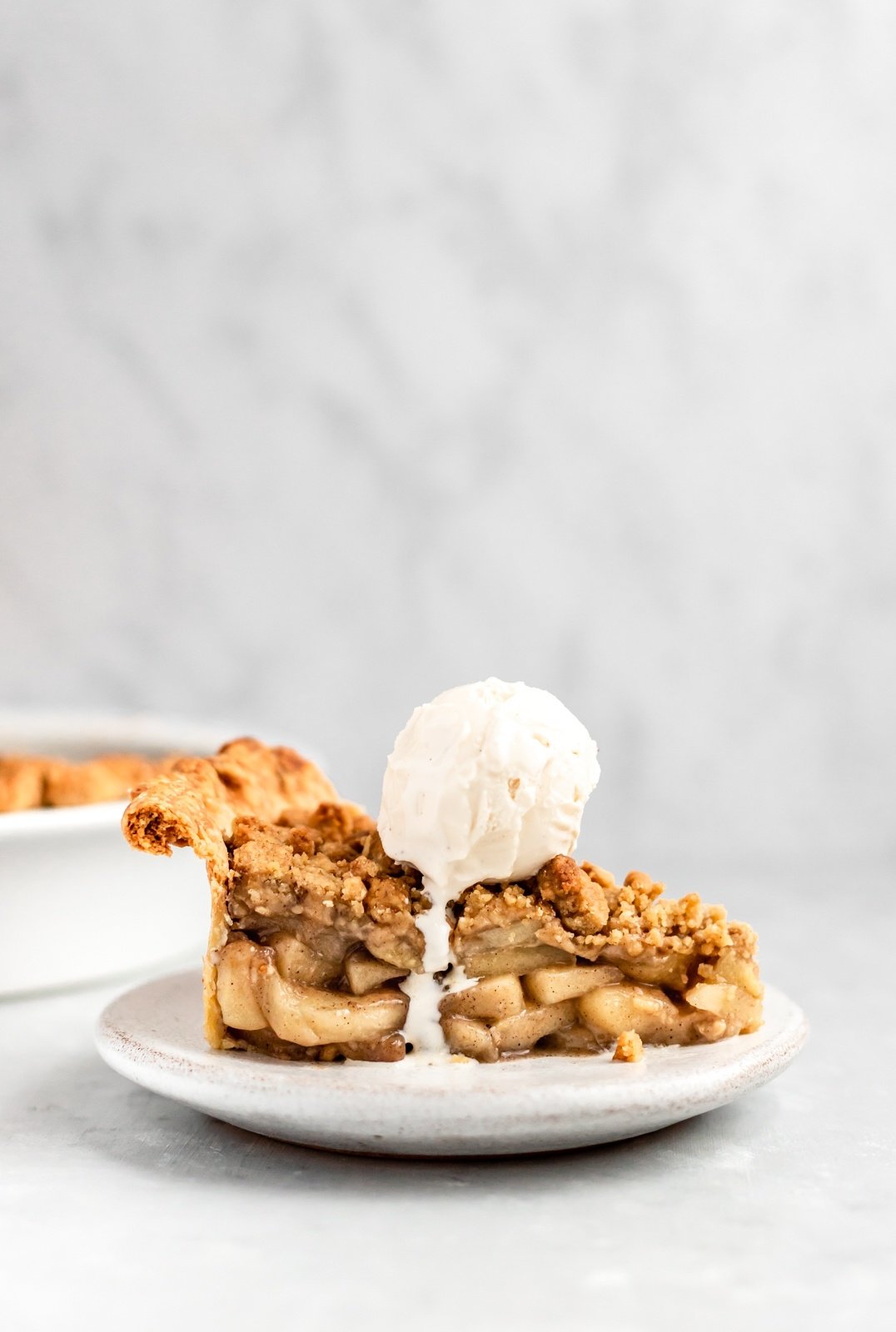 slice of dutch apple pie on a plate topped with ice cream