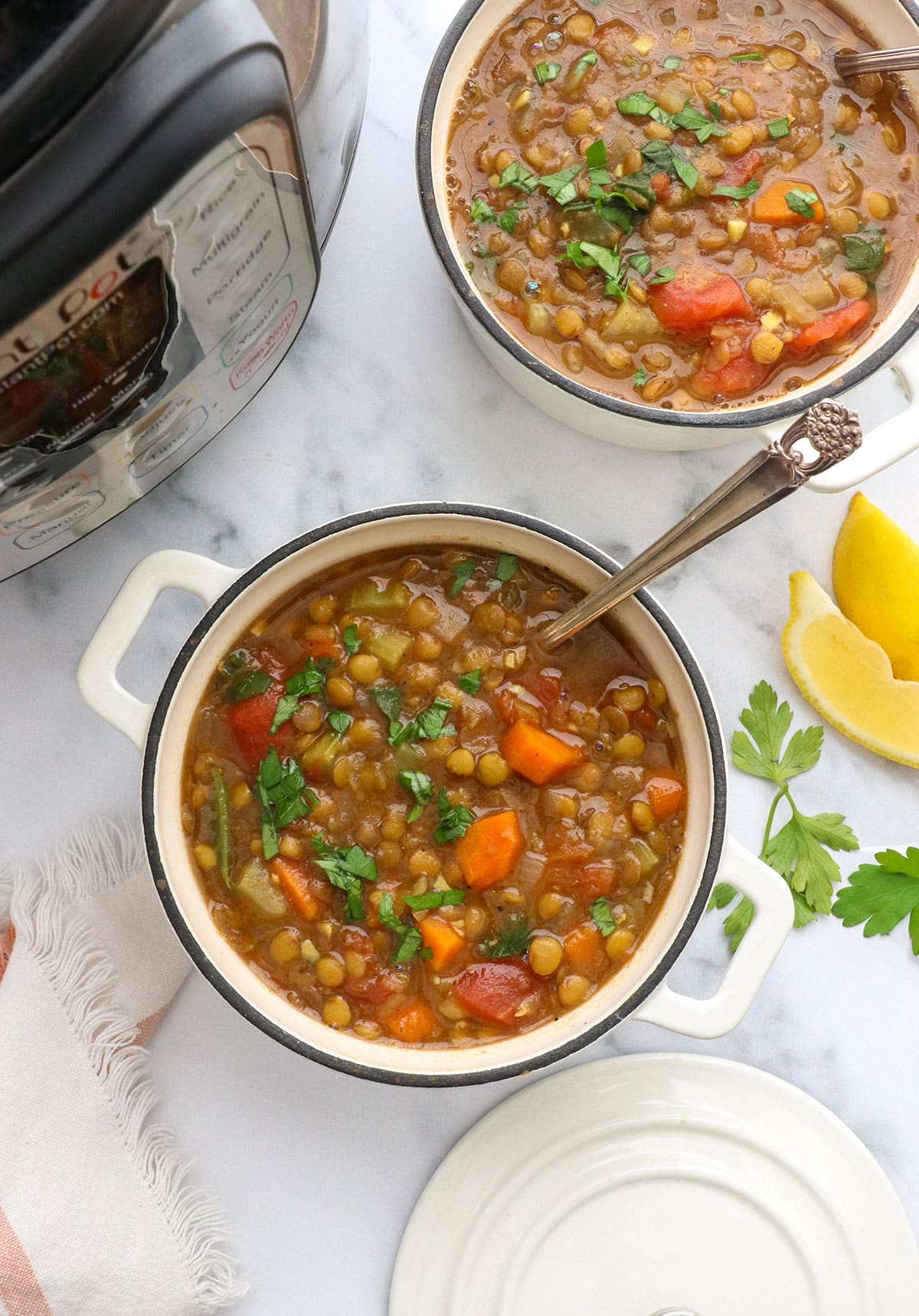 lentil soup in two white bowls near the instant pot. 