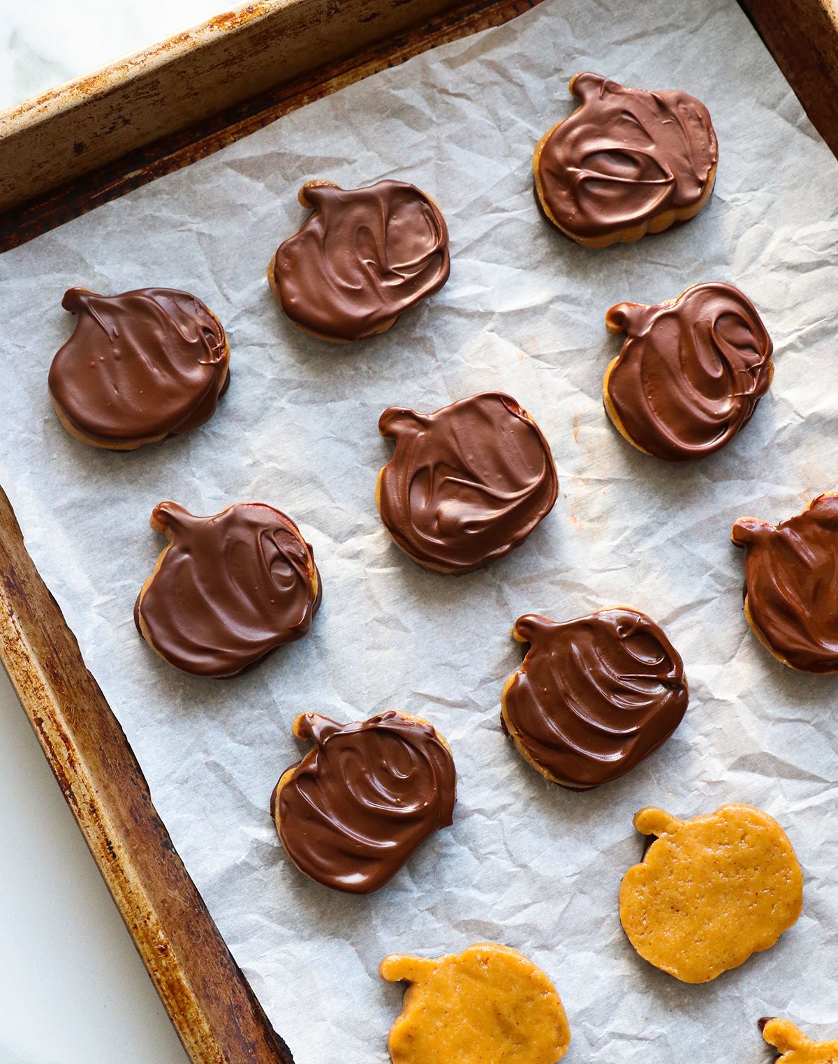 chocolate covered peanut butter pumpkins on a baking sheet. 