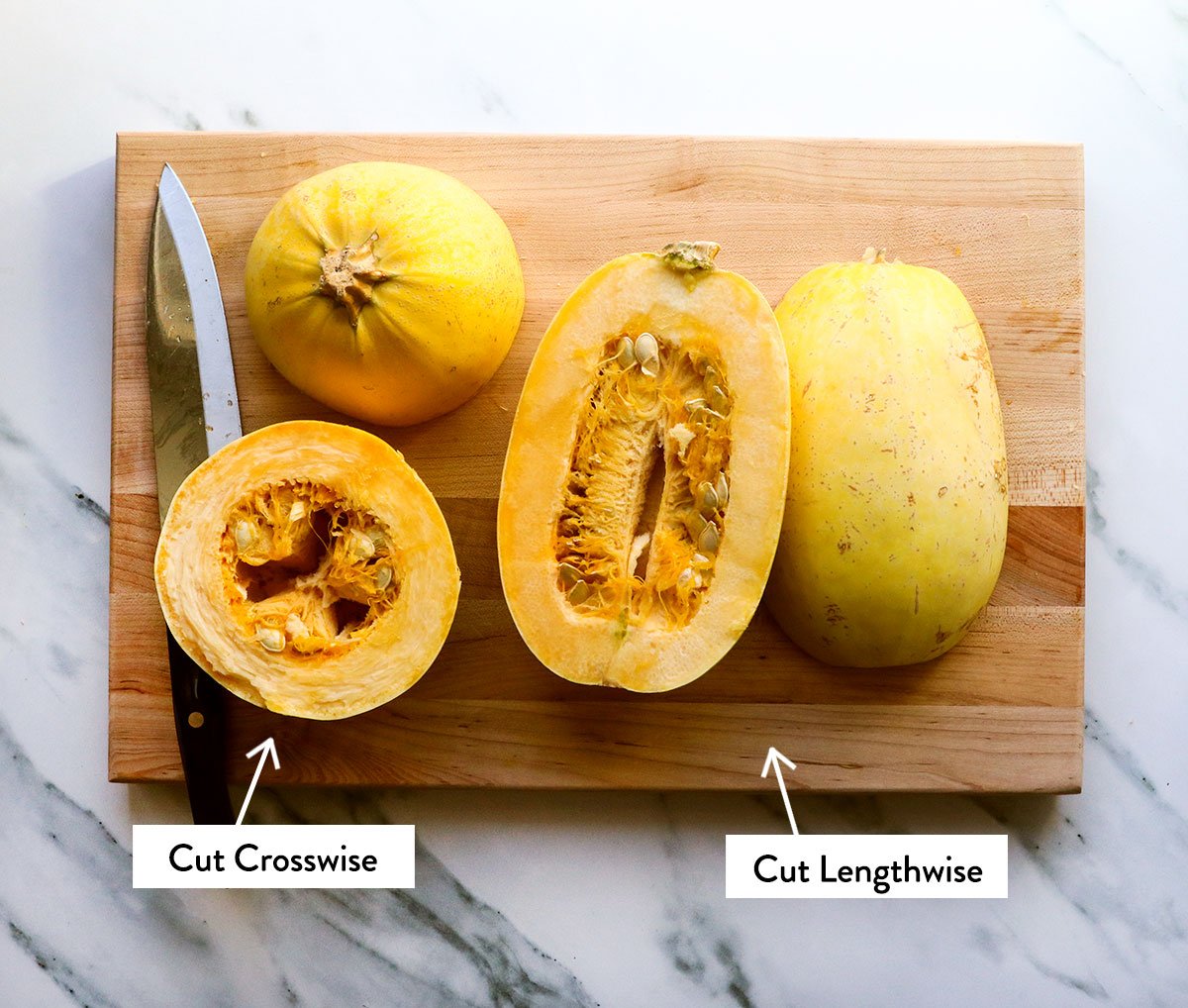 two spaghetti squash on a cutting board labeled crosswise and lengthwise.