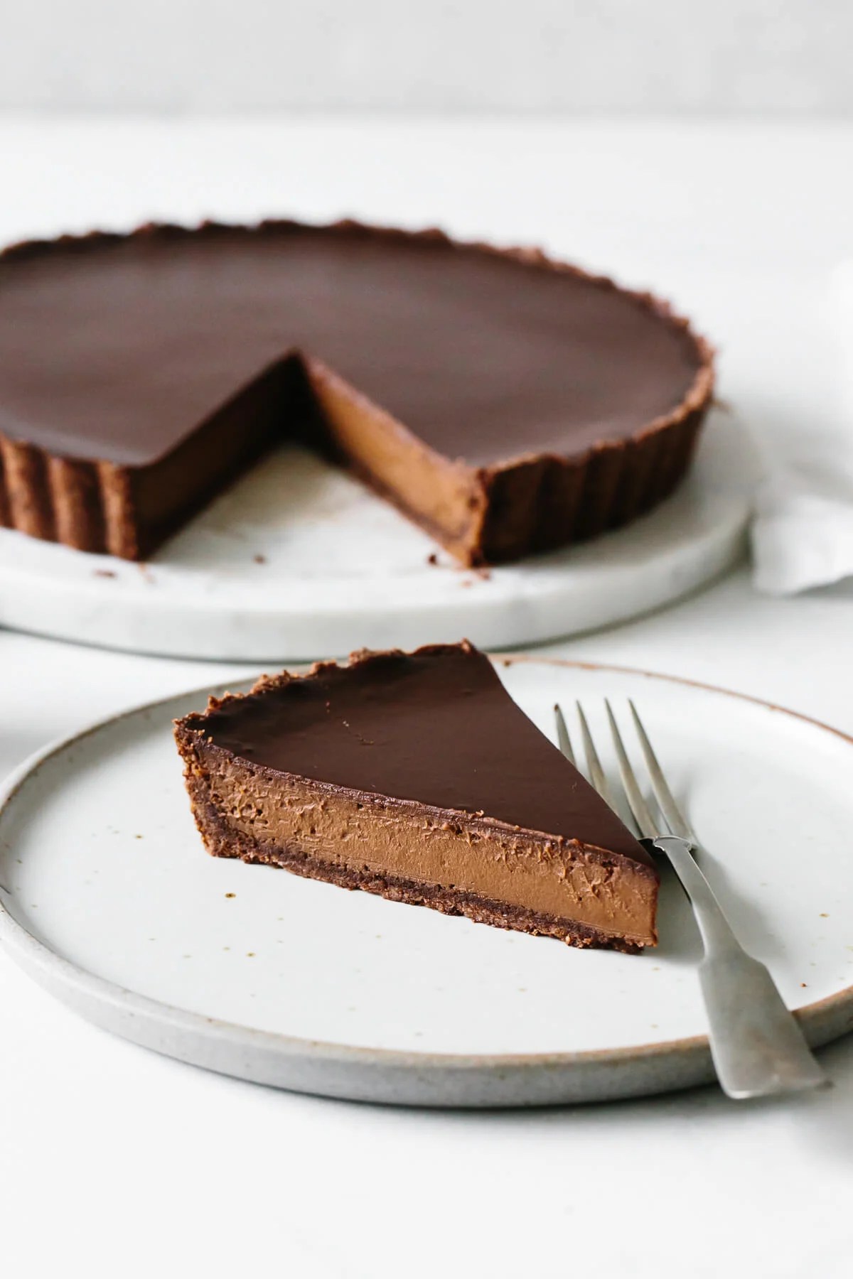 A single slice of chocolate tart on a plate.