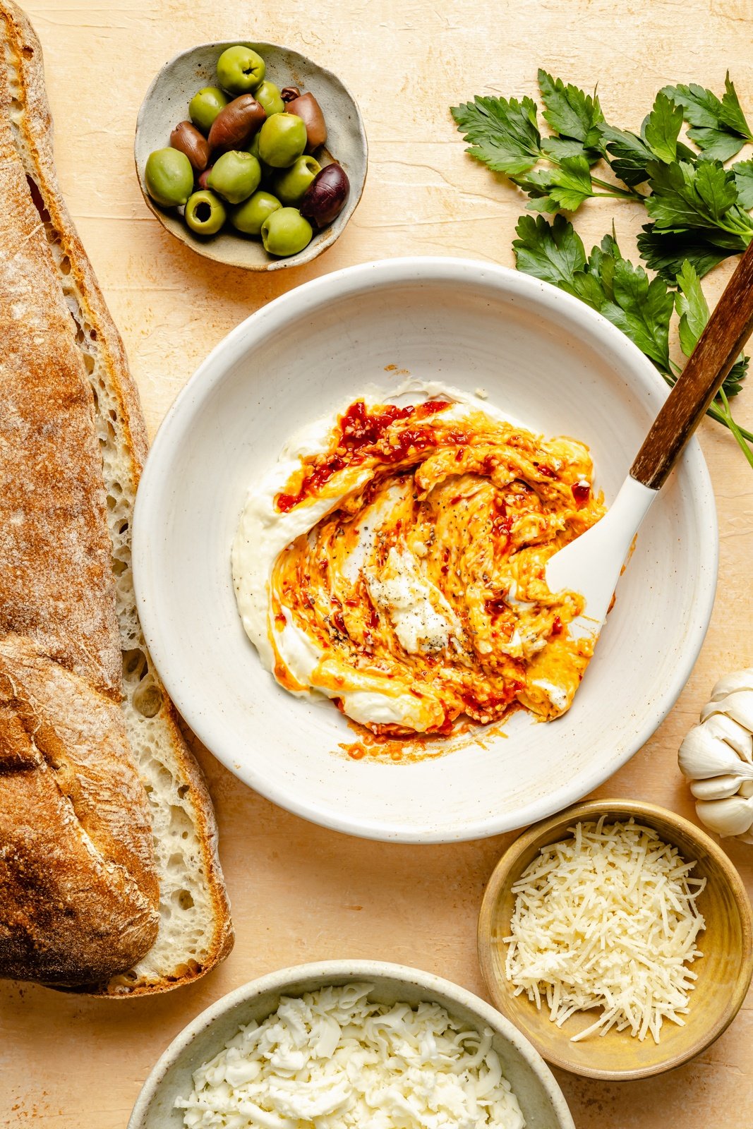 making a butter mixture for olive cheese bread in a bowl