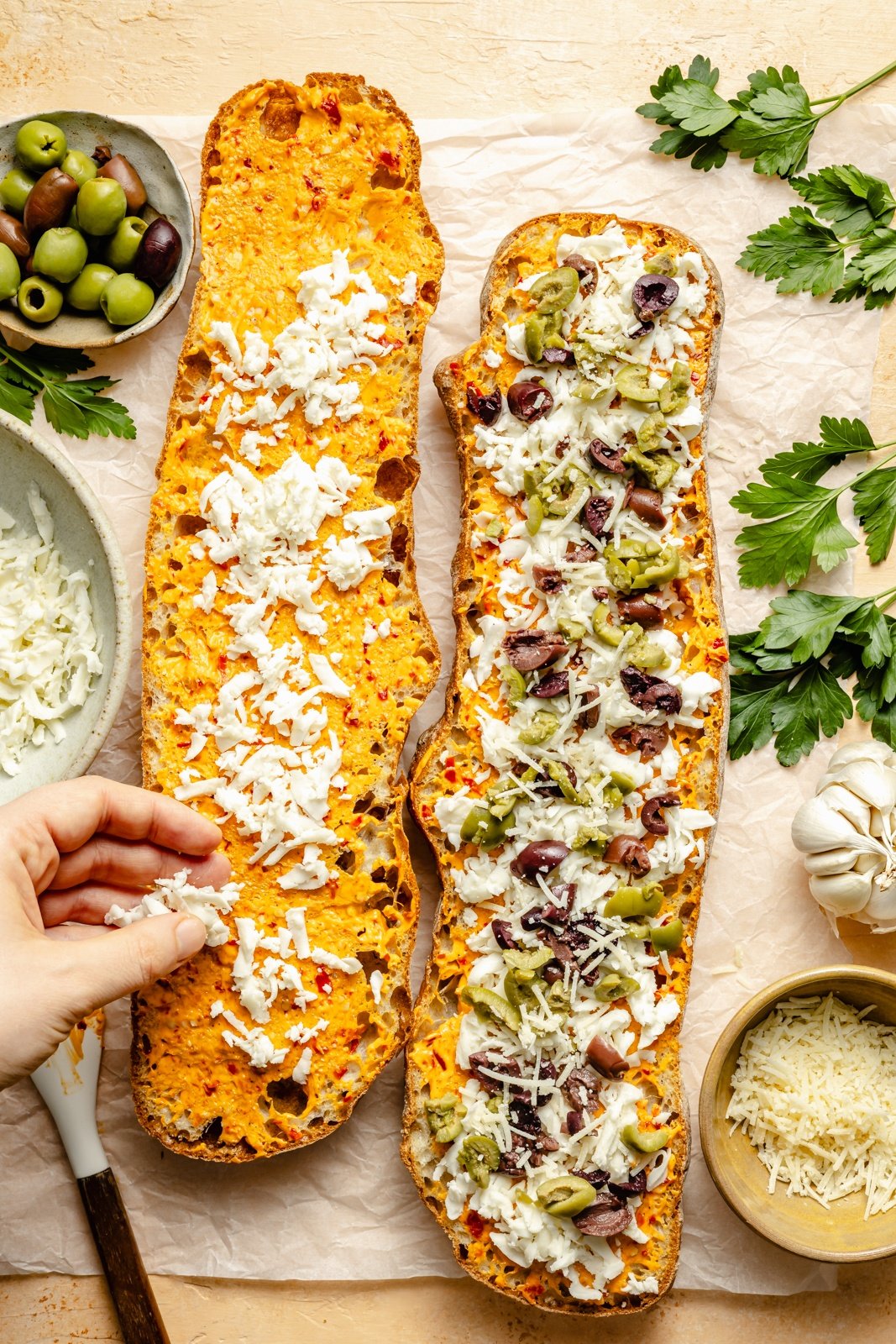 topping bread with cheese and olives