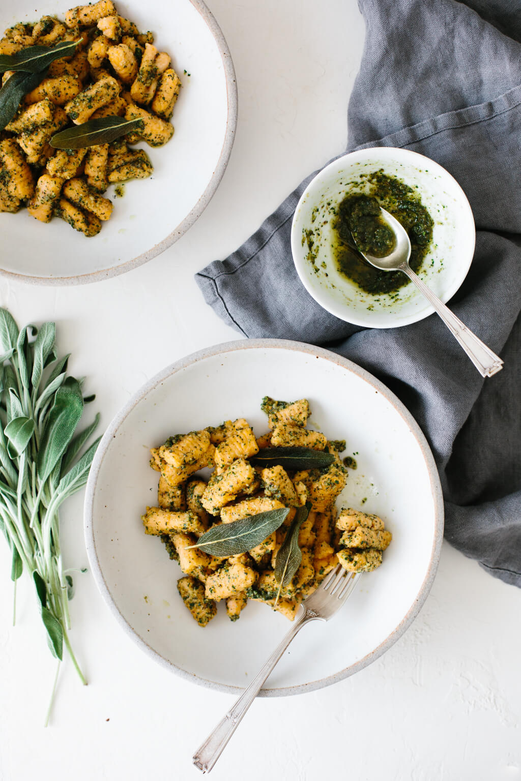 (gluten-free, paleo) Sweet potato gnocchi topped with a delicious sage walnut pesto. It's the perfect hearty and savory meal for fall and winter.