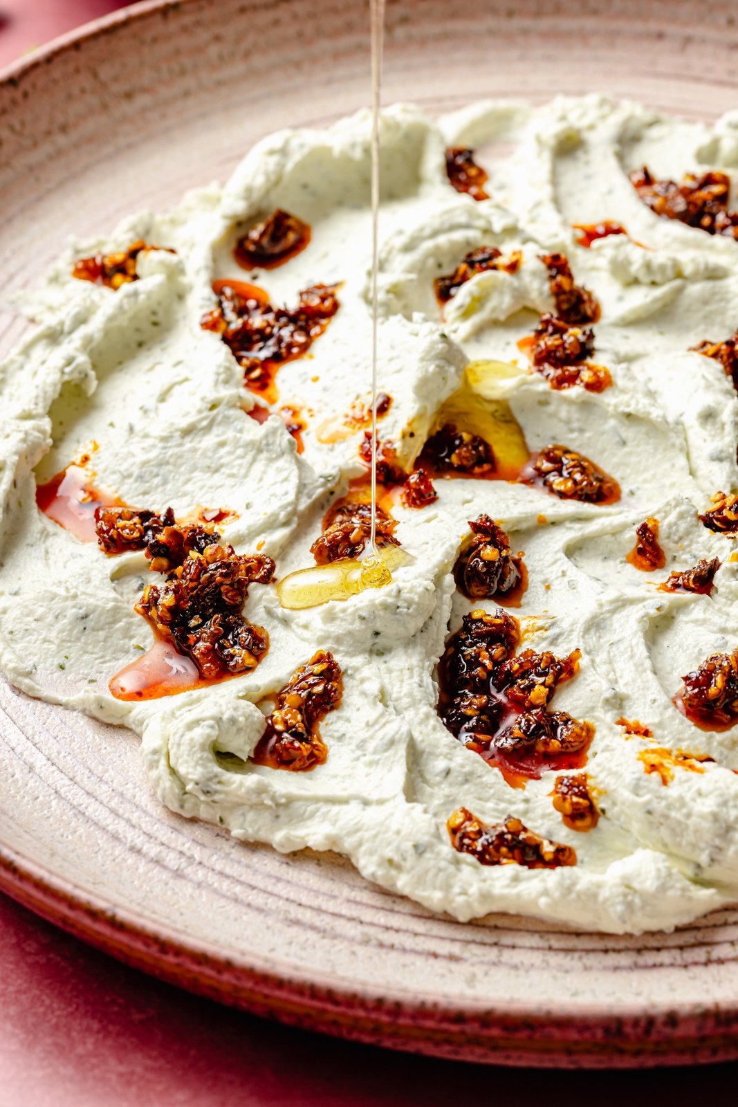 drizzling honey onto garlic herb cheese dip