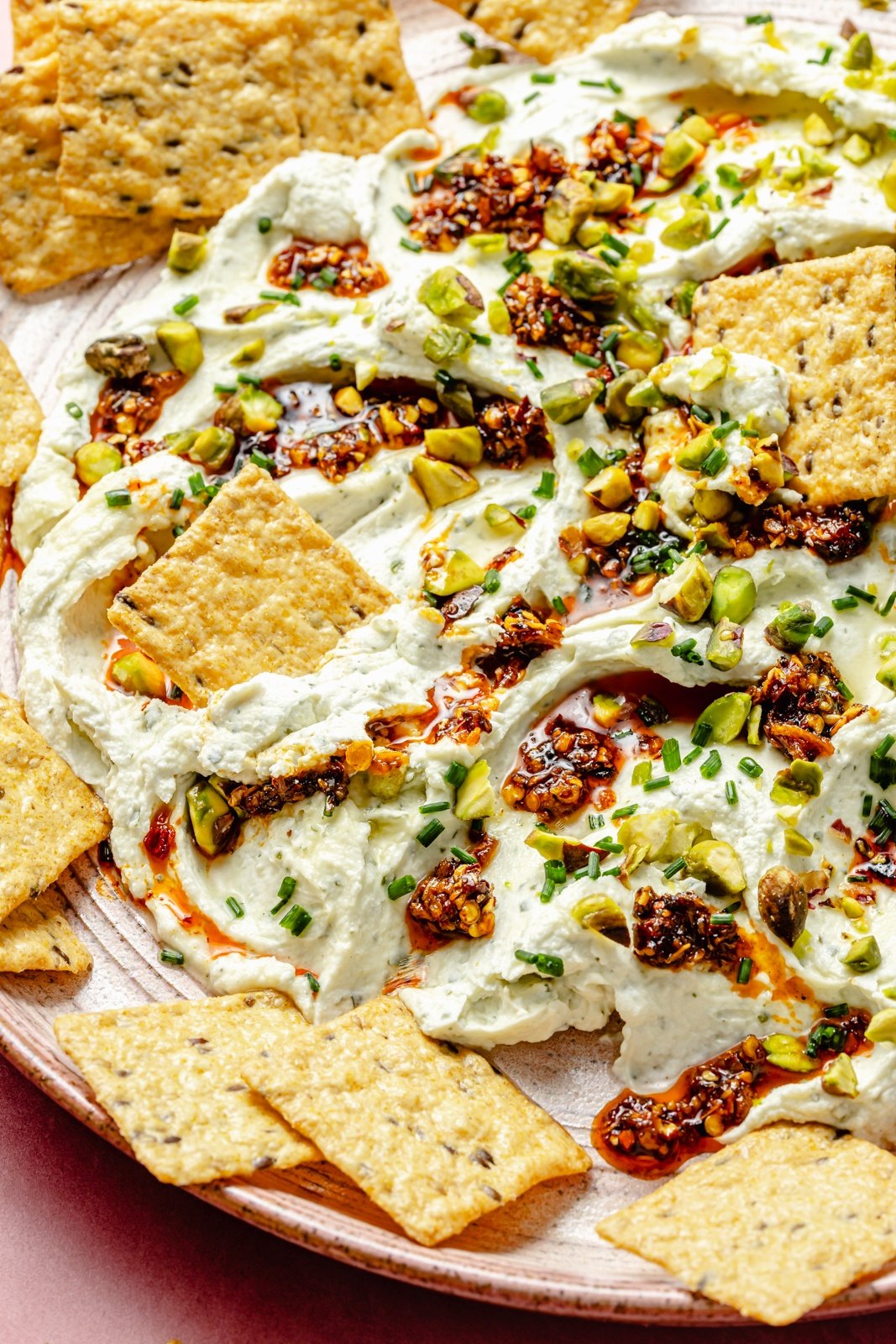 chili crisp cheese dip on a platter with crackers