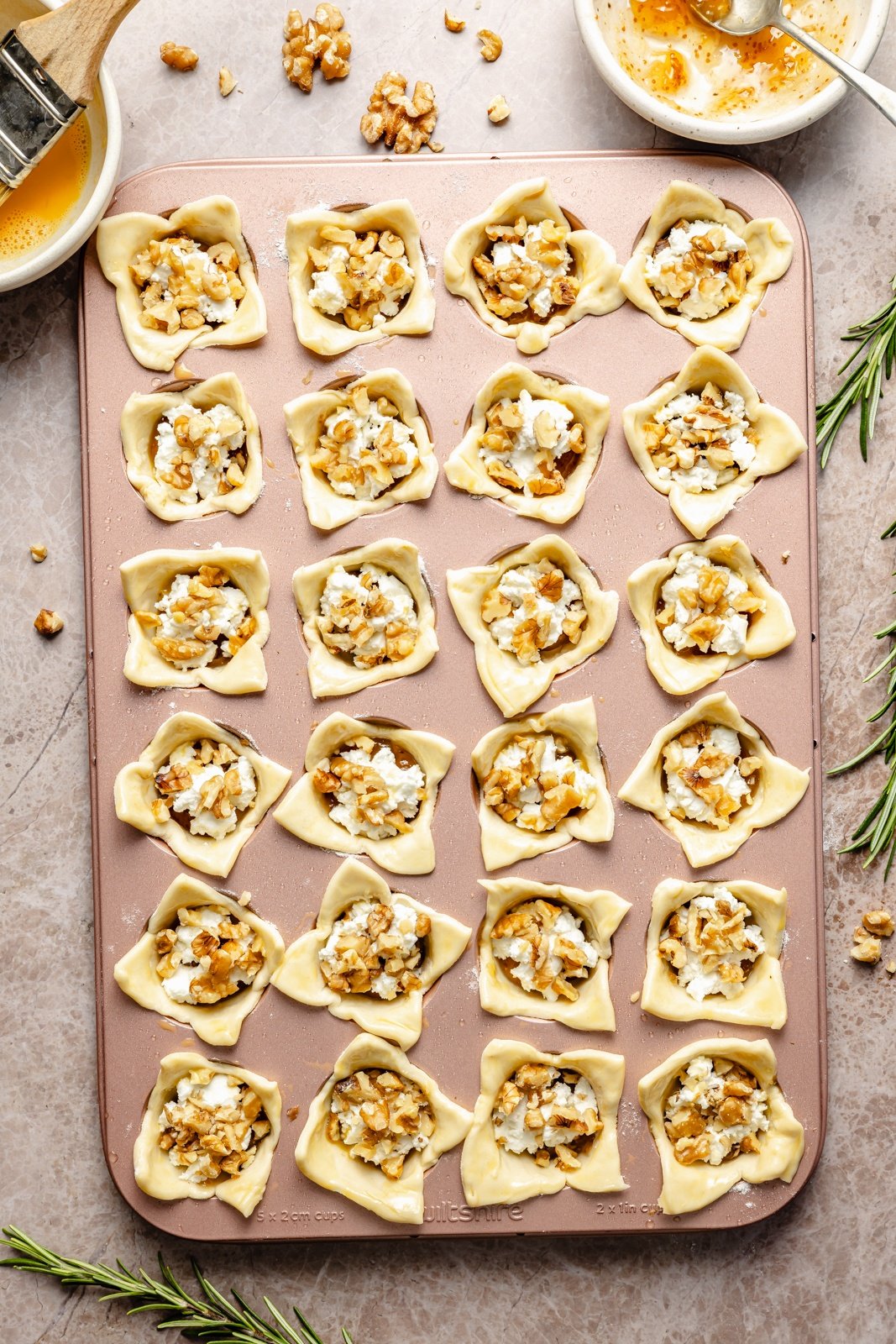 unbaked fig and goat cheese puff pastry bites in a mini muffin tin