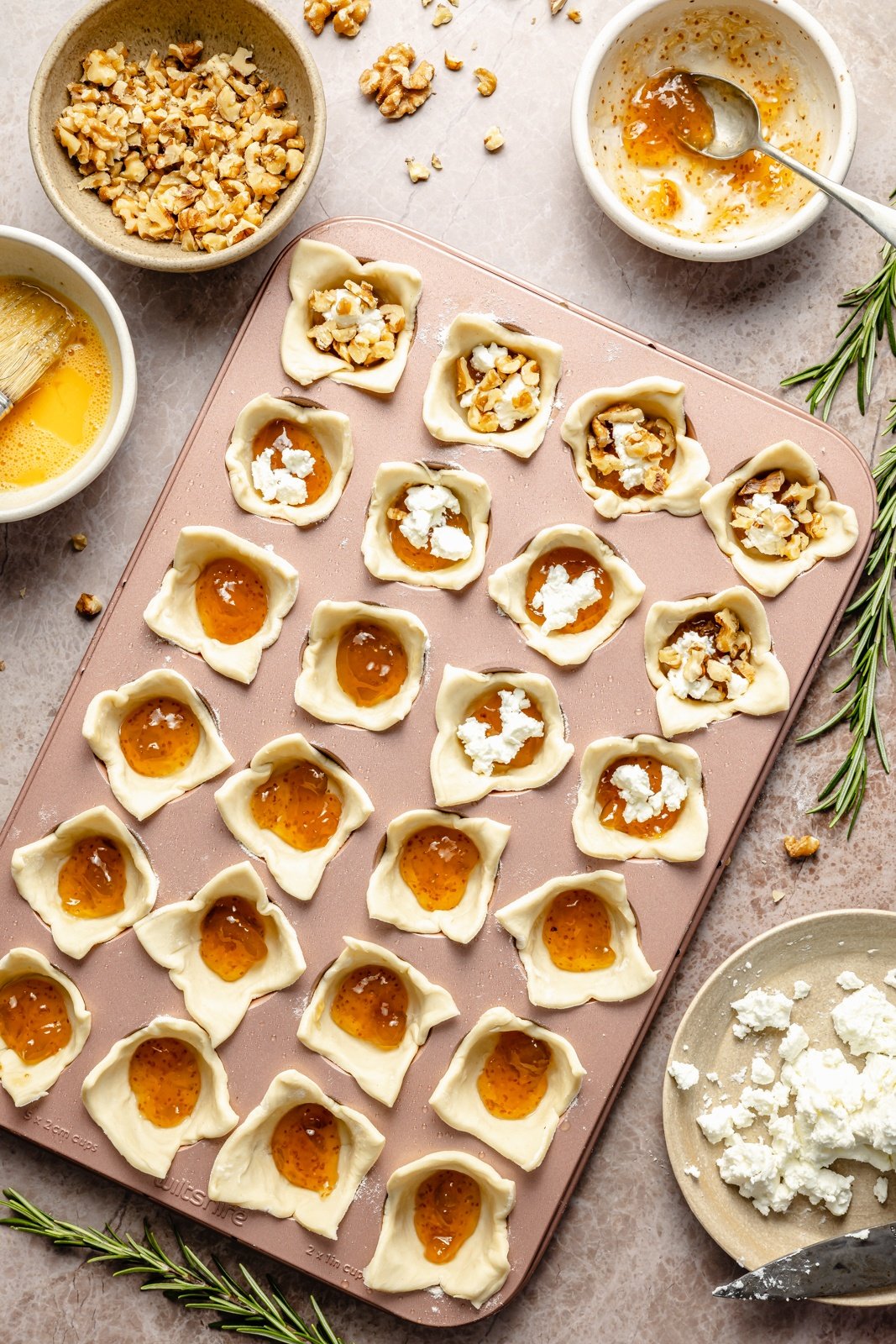 filling puff pastry bites in a mini muffin tin